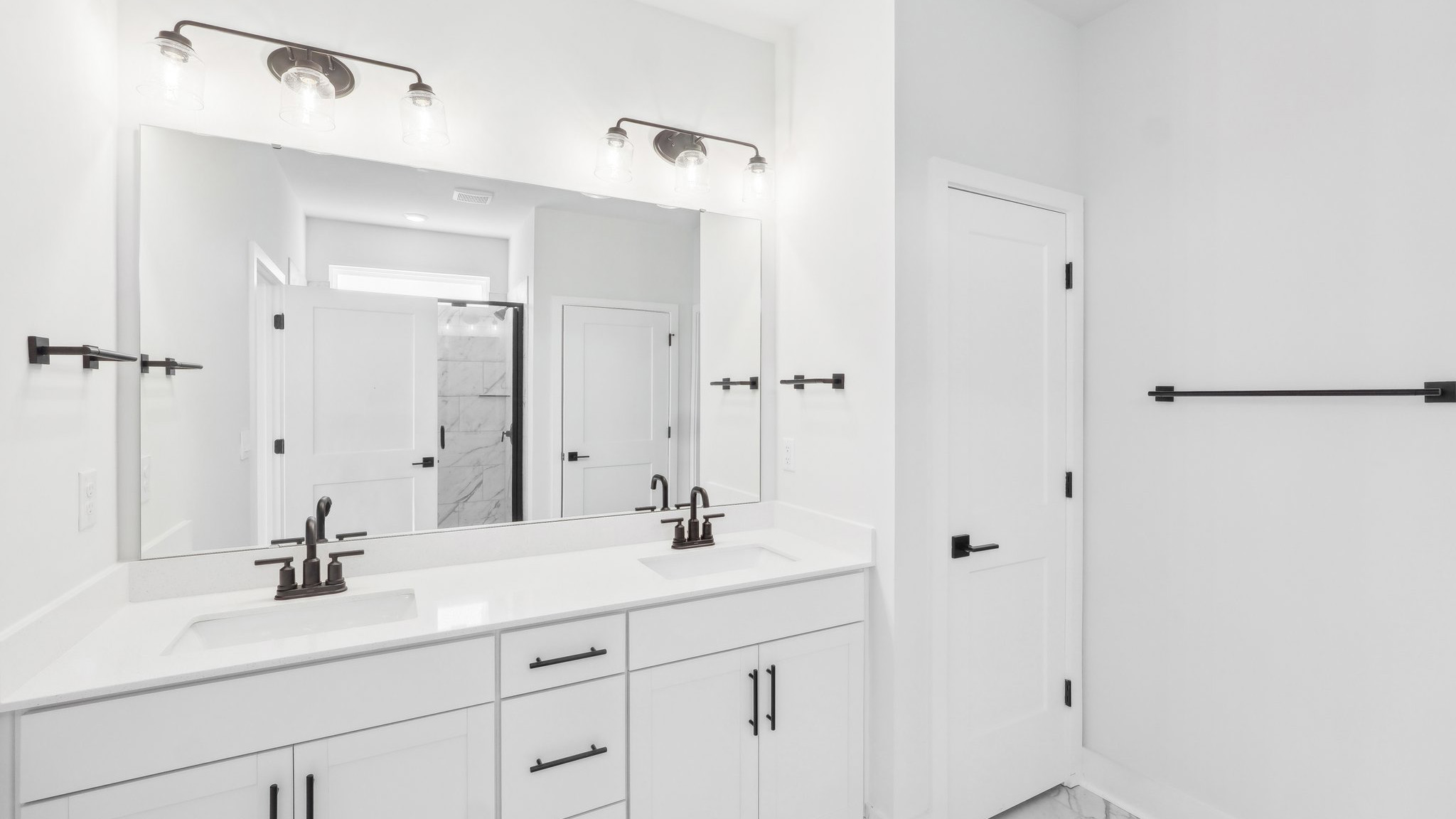 Primary bathroom with double sink vanity and large glass door shower