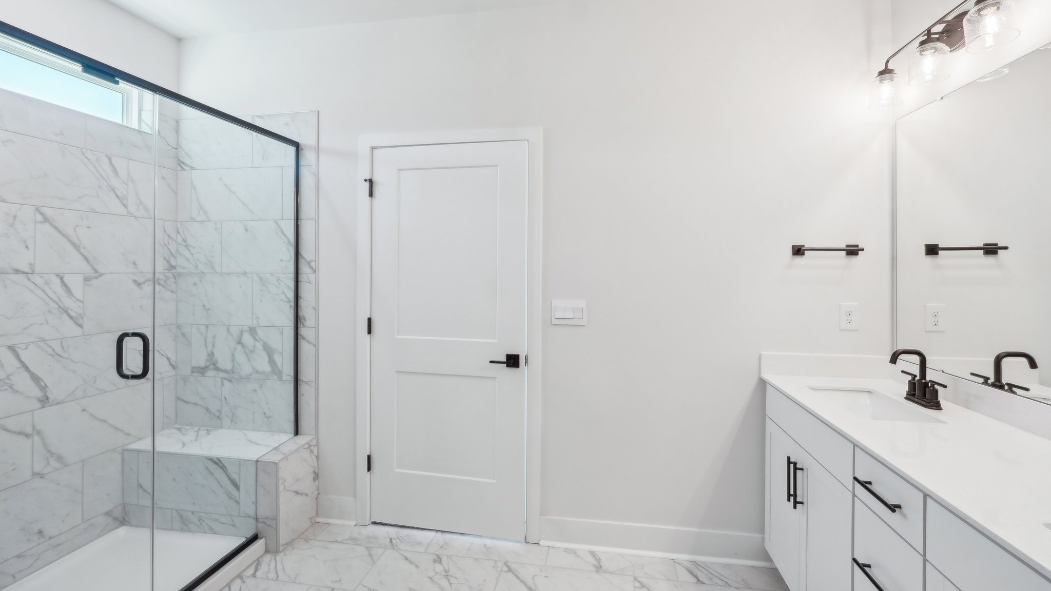 Primary bathroom with double sink vanity and large glass door shower