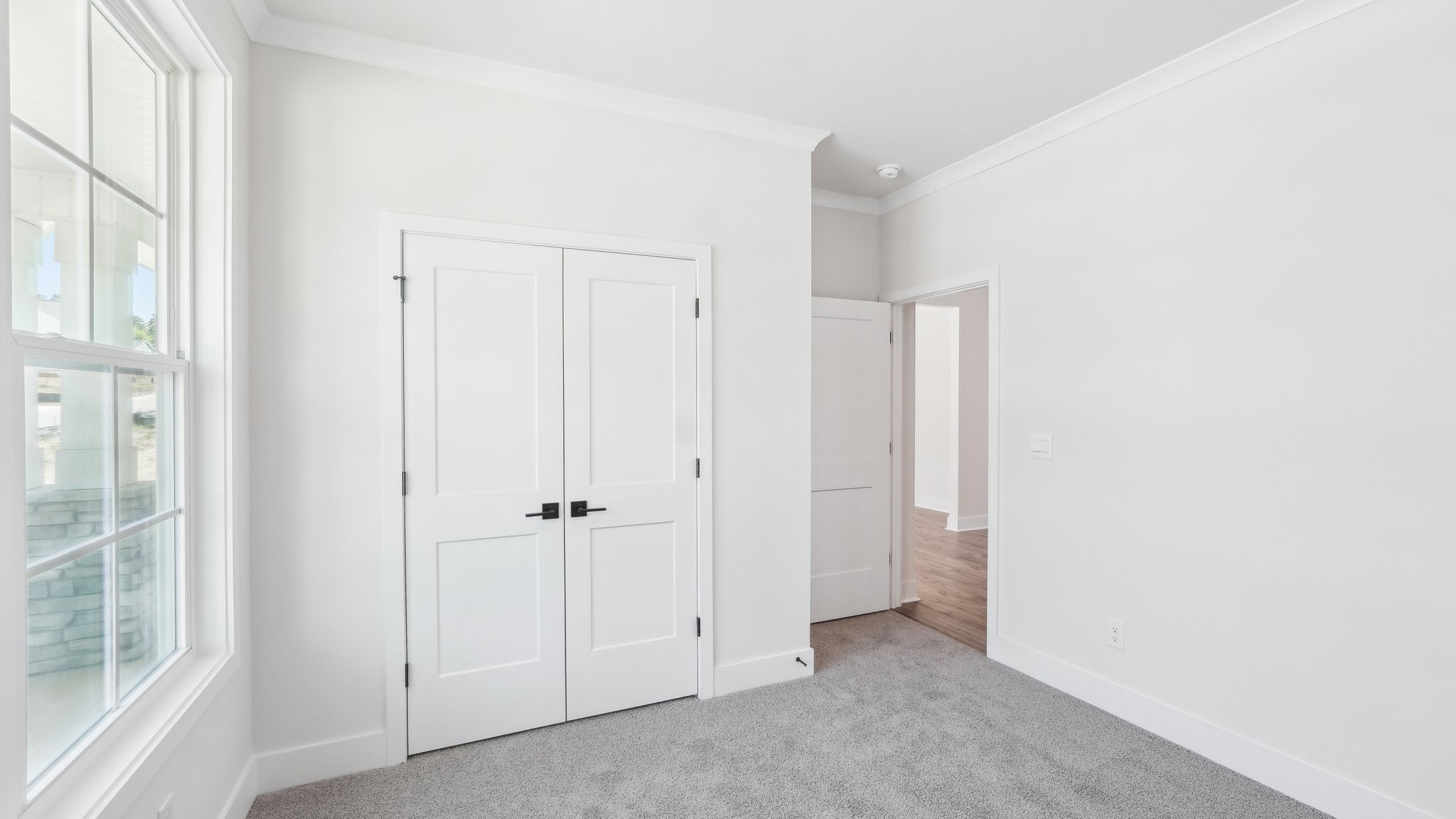 Carpeted bedroom with large windows