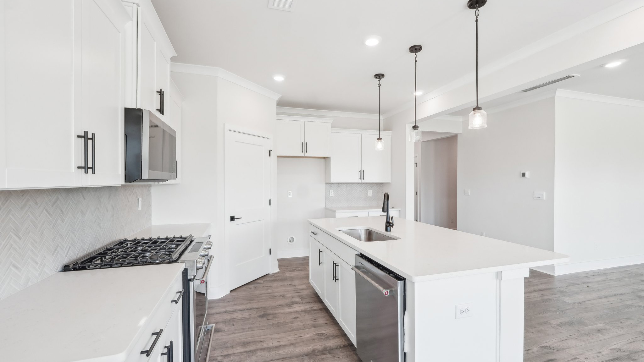 Kitchen and island with tile backsplash and stainless steel appliances