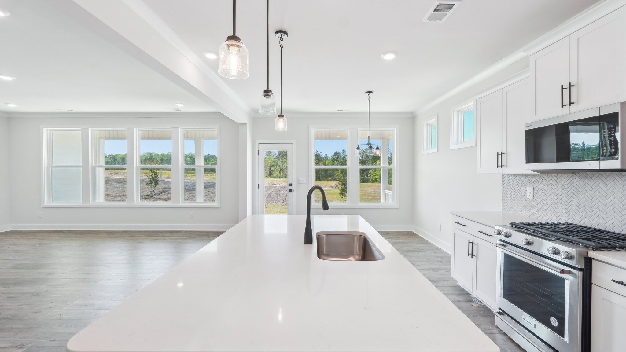 Kitchen and island with tile backsplash and stainless steel appliances