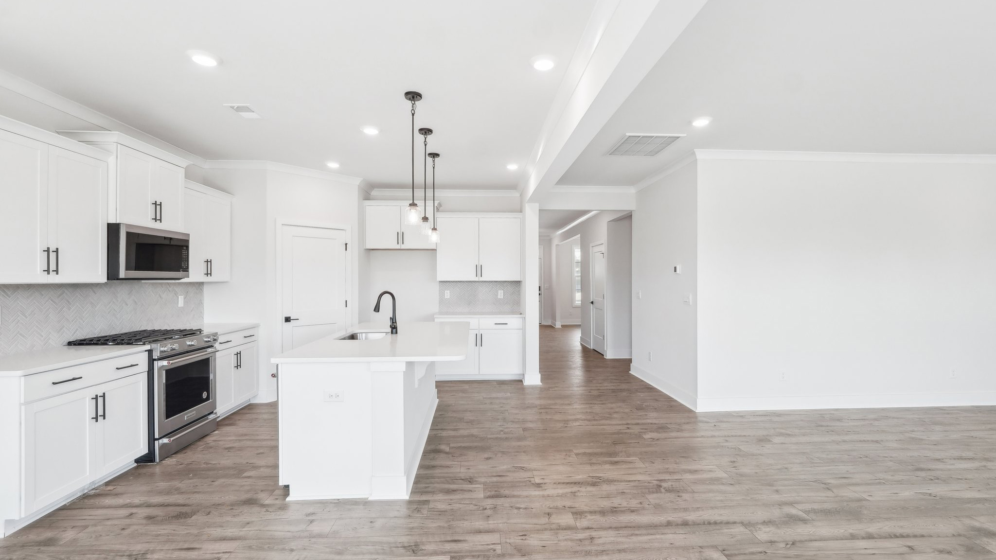 Kitchen and island with tile backsplash and stainless steel appliances