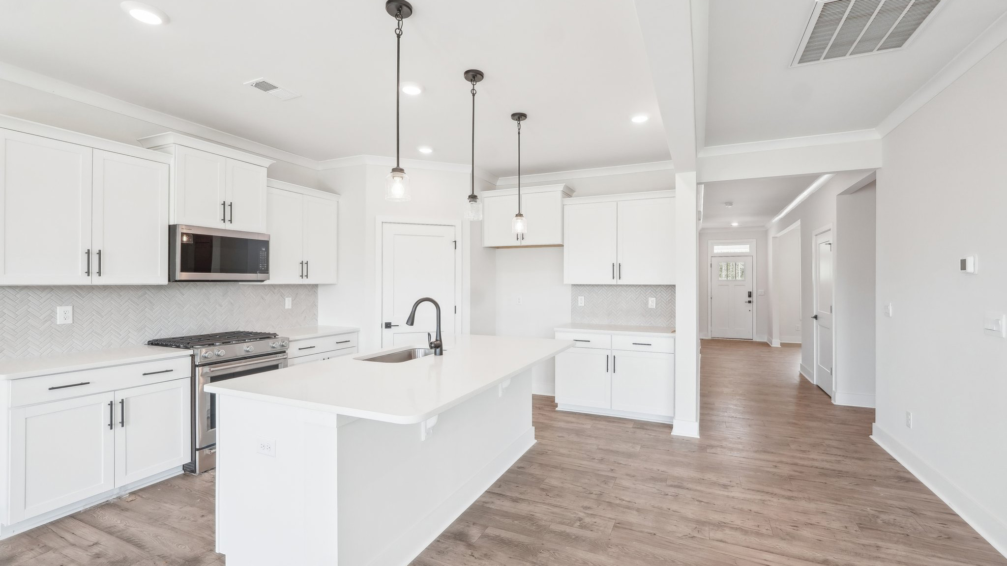 Kitchen and island with tile backsplash and stainless steel appliances