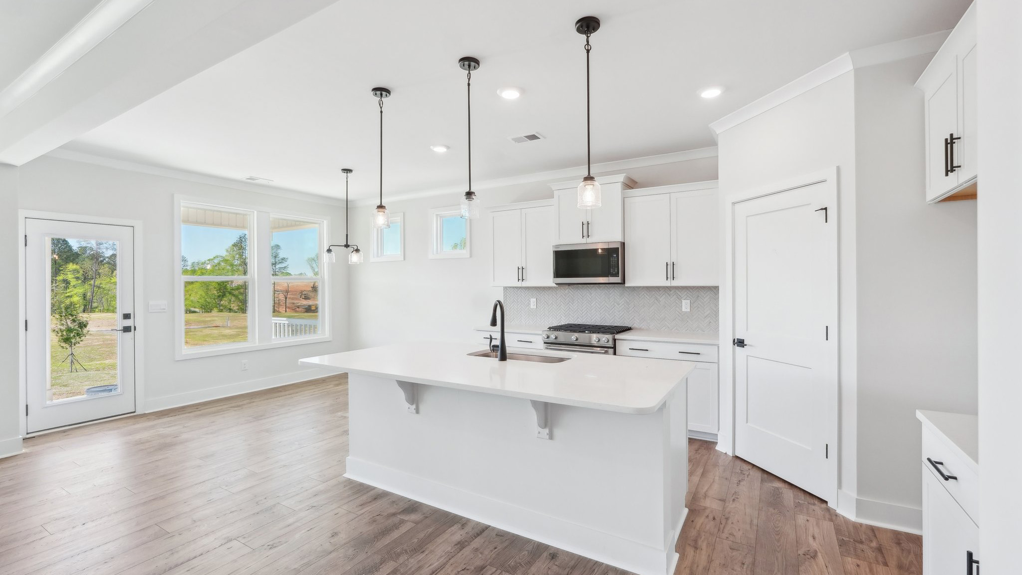 Kitchen and island with tile backsplash and stainless steel appliances