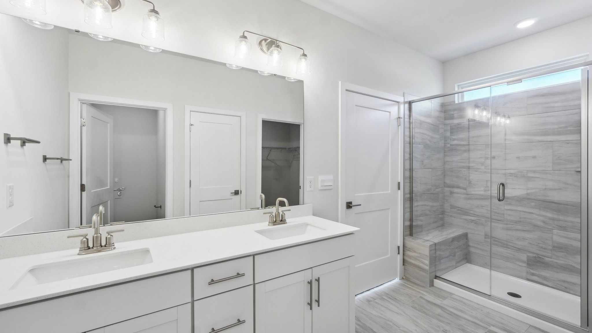 Primary bathroom with double sink vanity and large standing shower