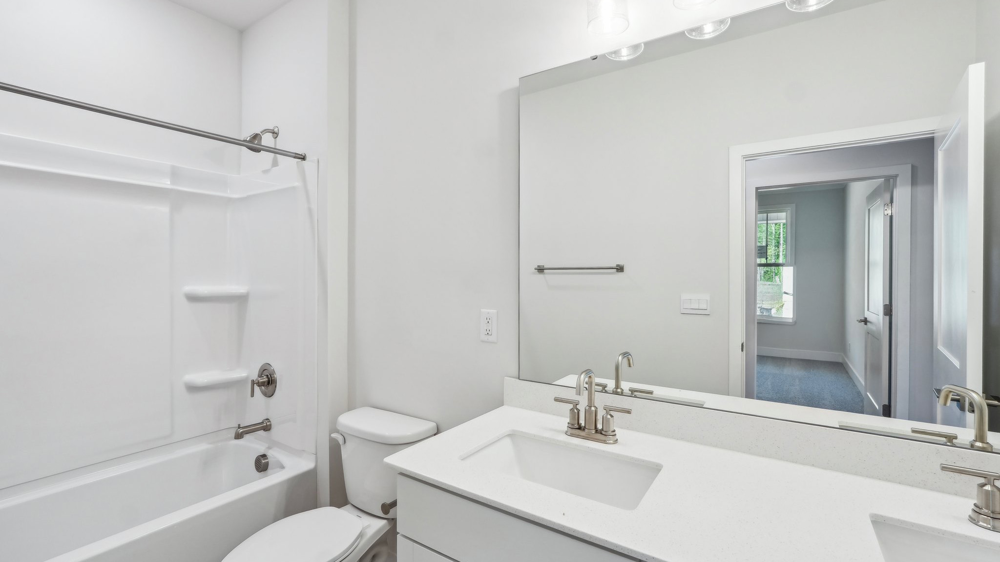 Bathroom with double sink vanity and bathtub and shower combination