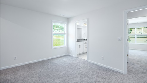 Large carpeted bedroom with small window
