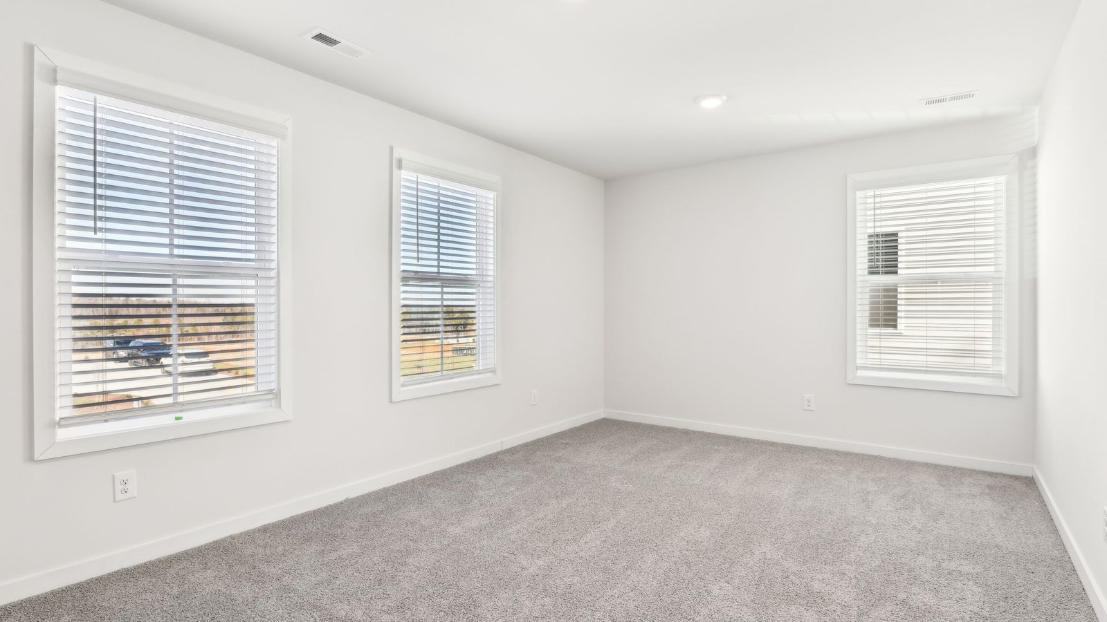 carpeted bedroom with two large windows