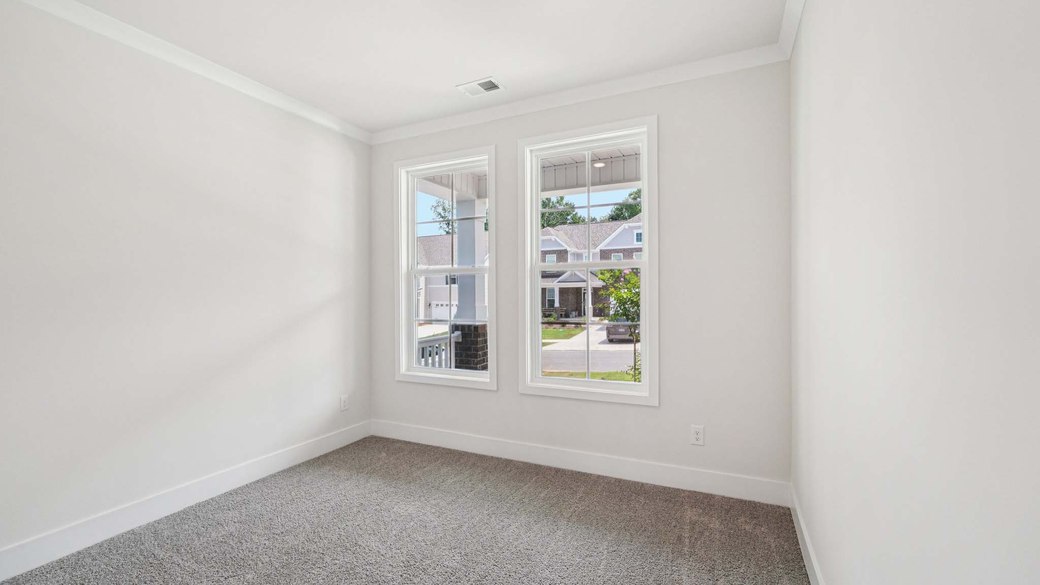 Carpeted bedroom with 2 large windows