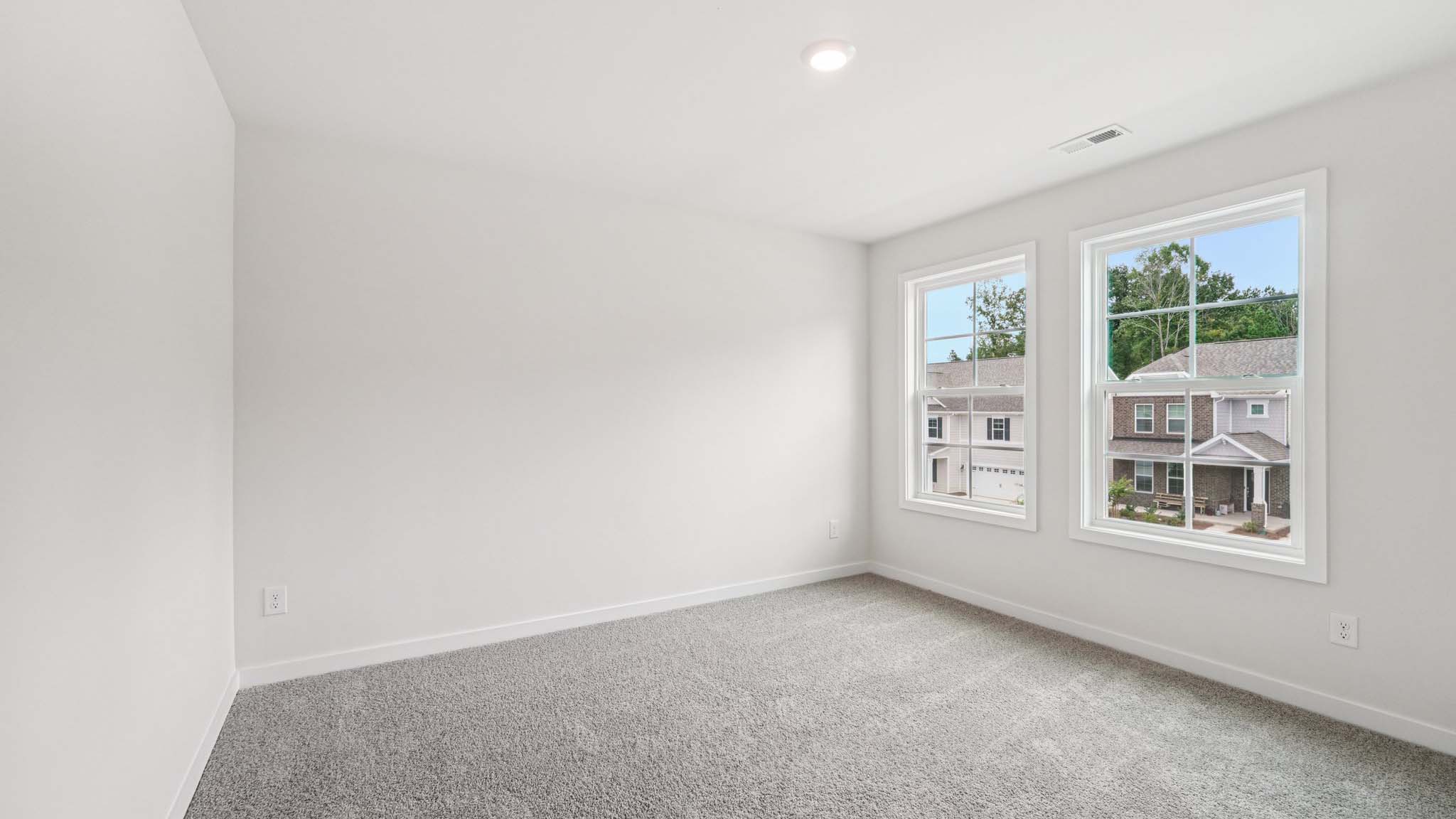 Carpeted bedroom with 2 large windows