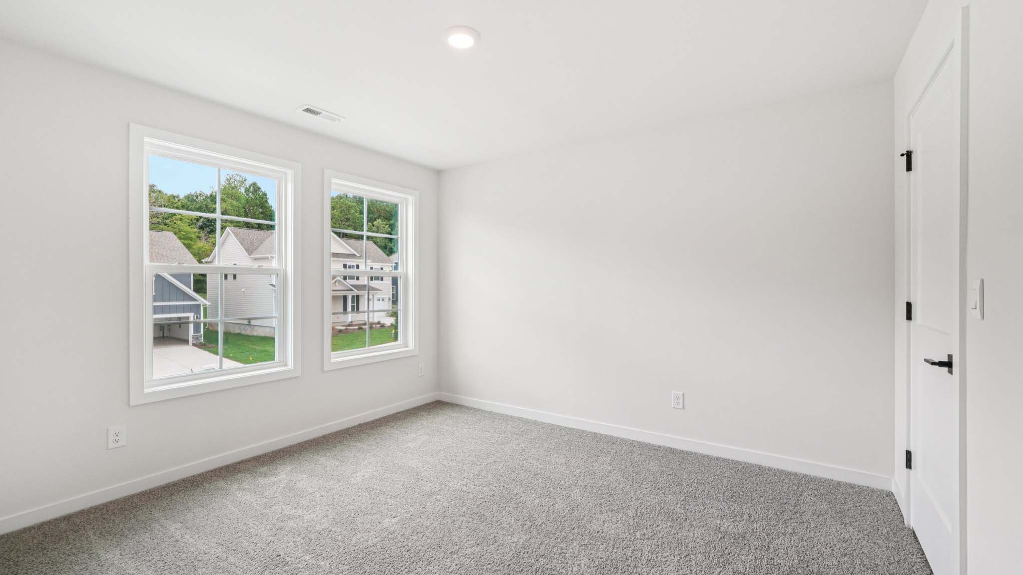 Carpeted bedroom with 2 large windows