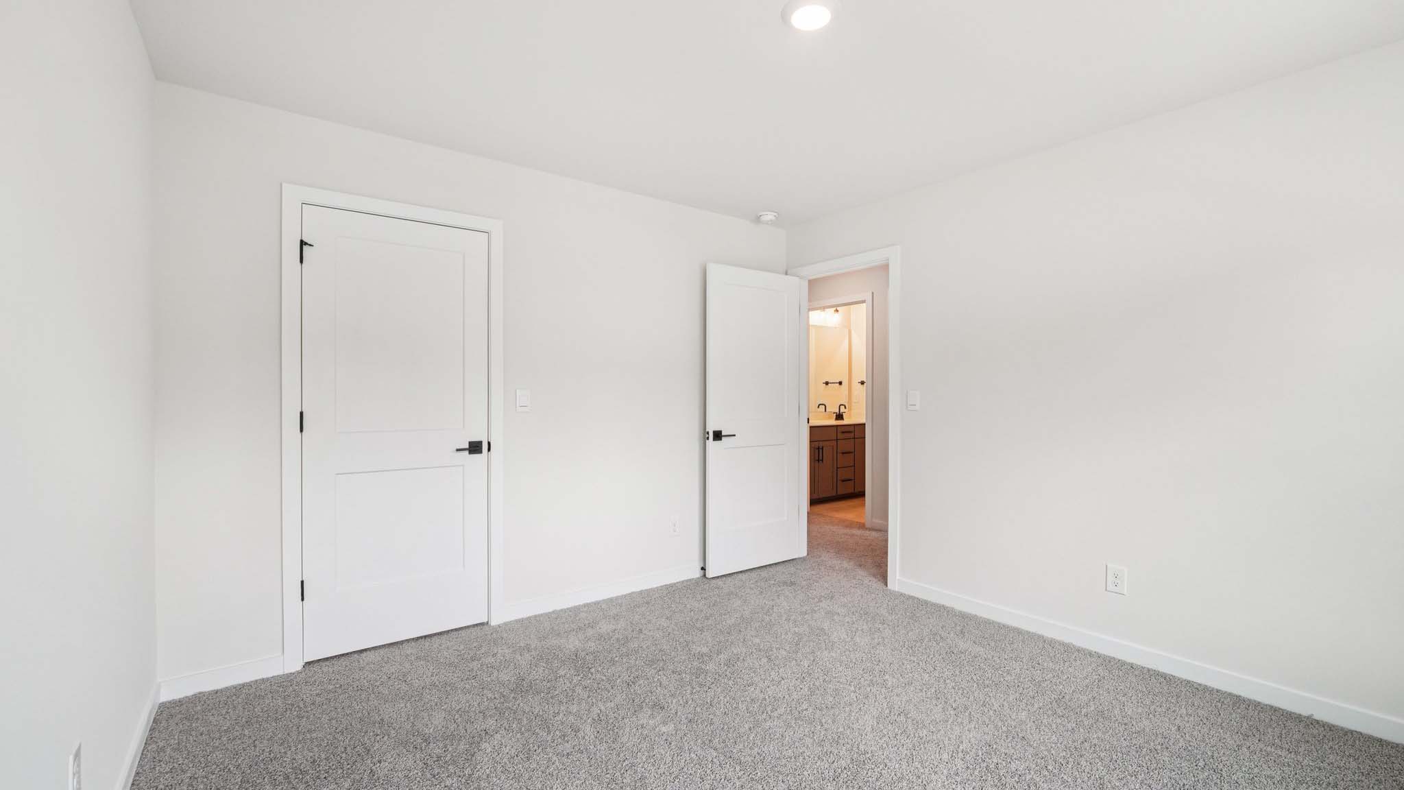 Primary carpeted bedroom with large windows