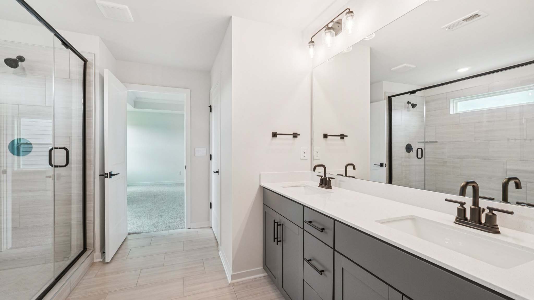 bathroom with double sinks, and separate toilet and bathtub and shower combination