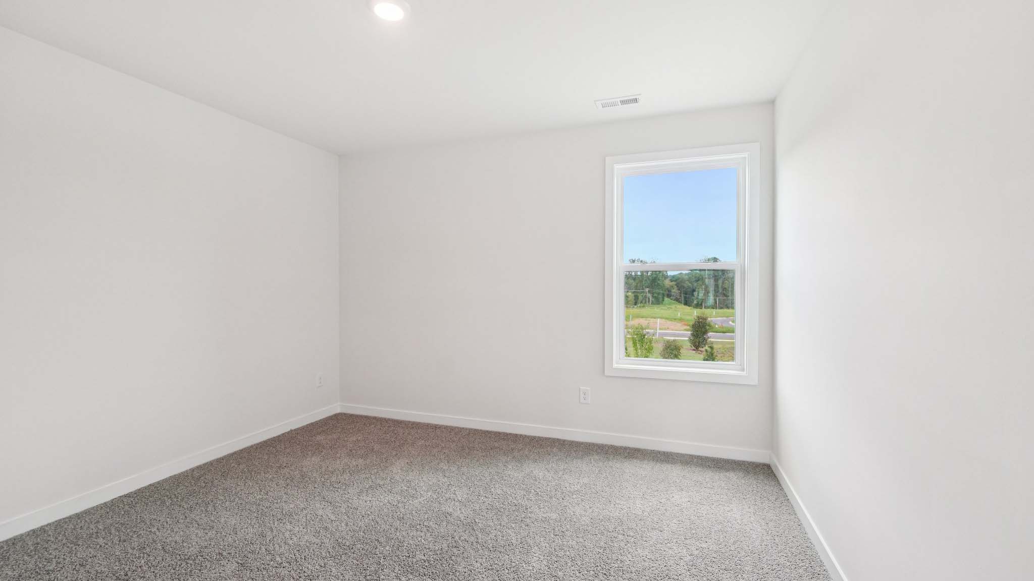 carpeted bedroom with two large windows