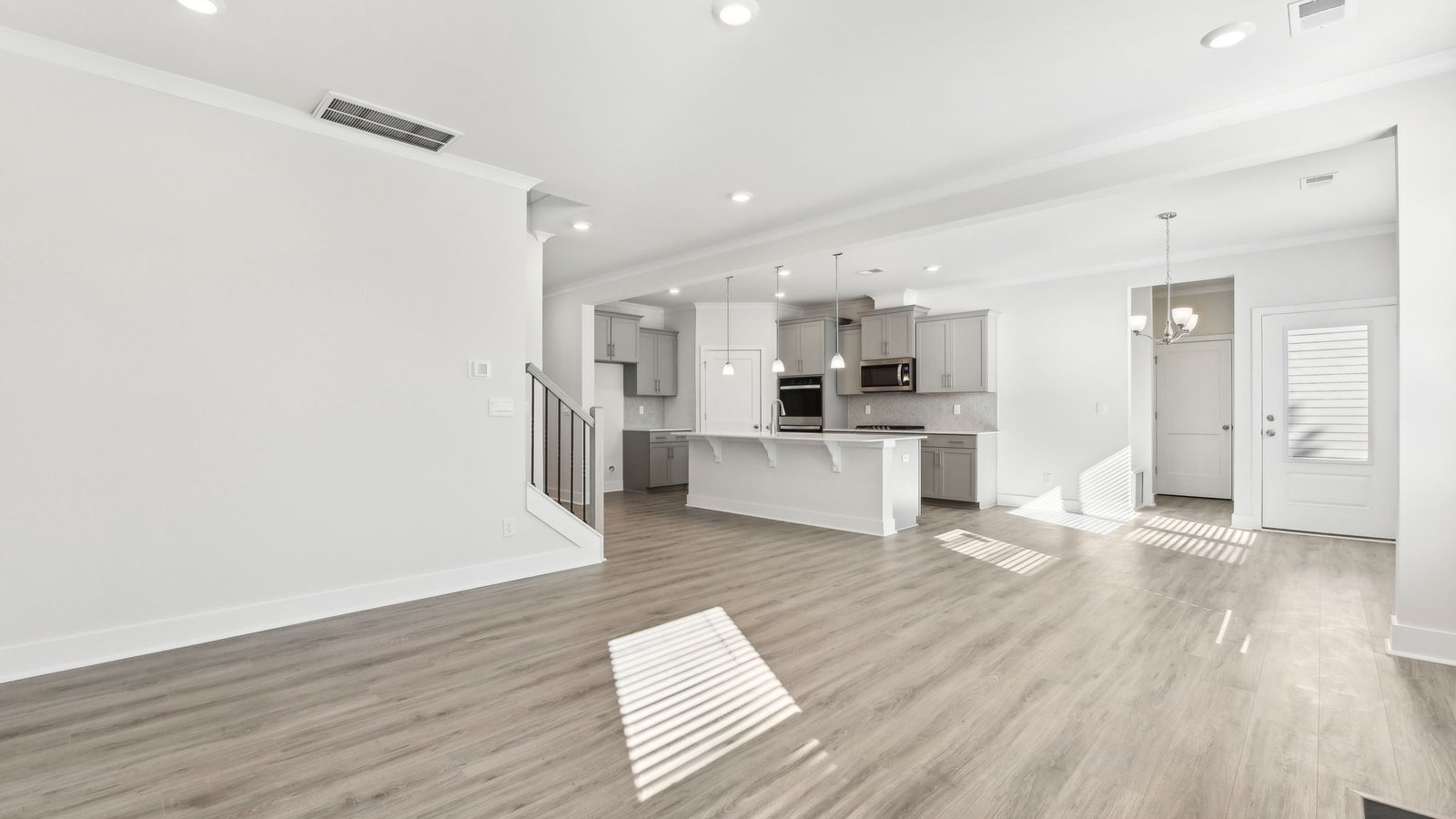 Open concept family room with two large windows and a fireplace