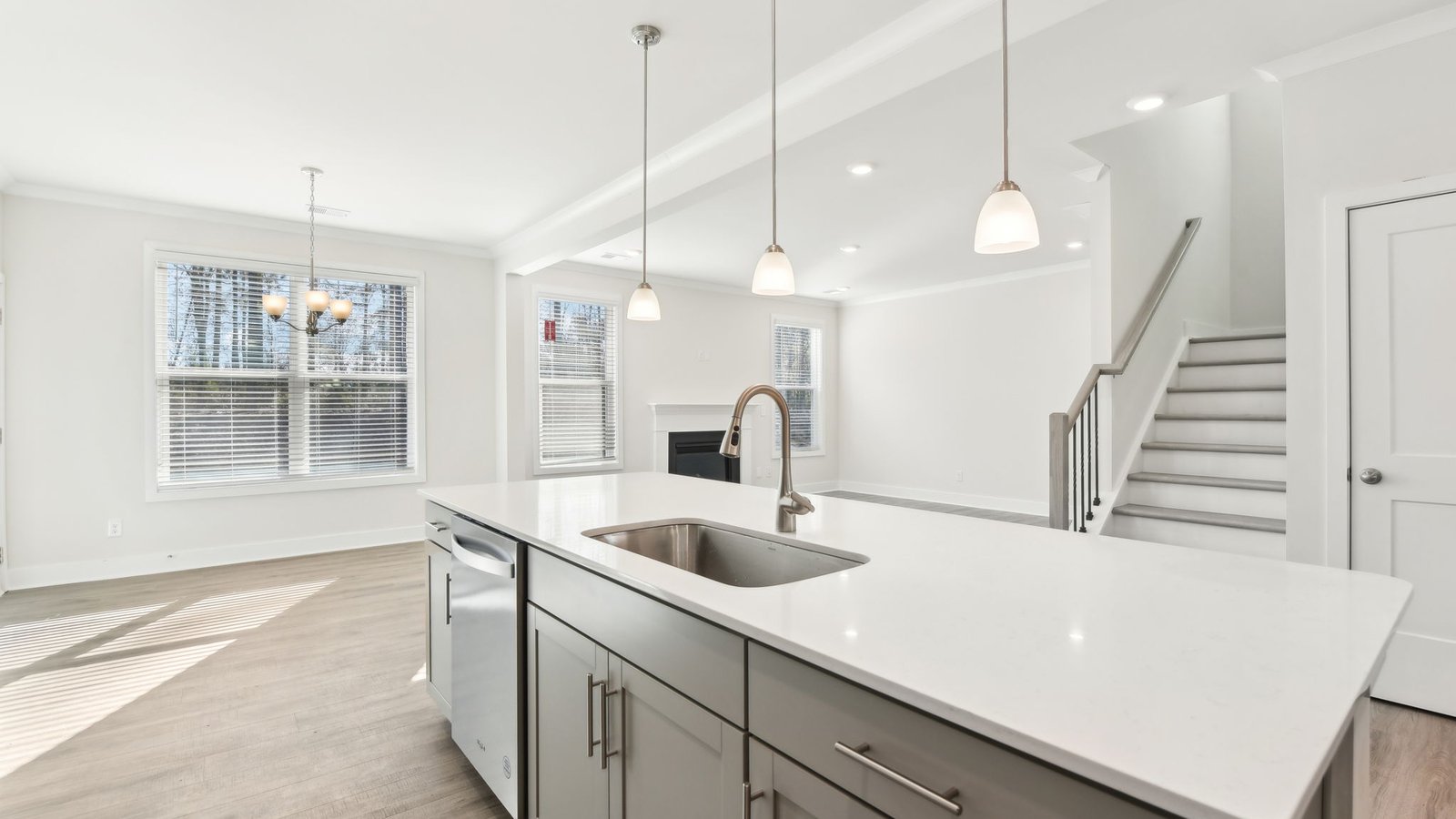 Open concept kitchen with gray cabinets, white countertops and stainless steel appliances