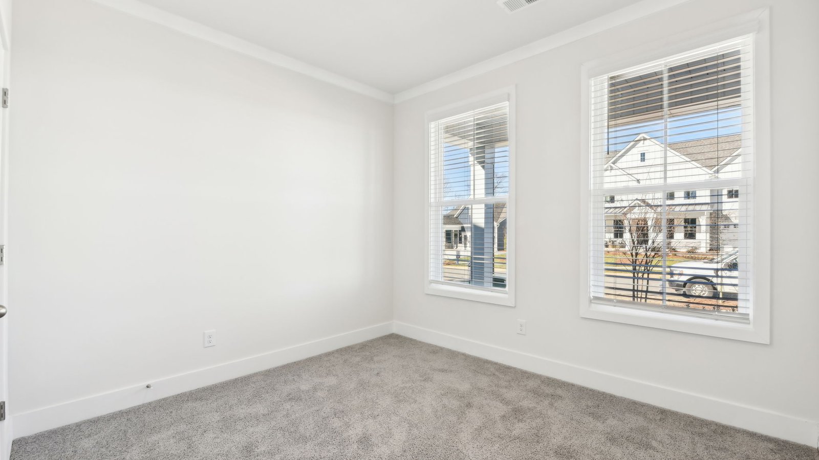 Carpeted bedroom with 2 large windows