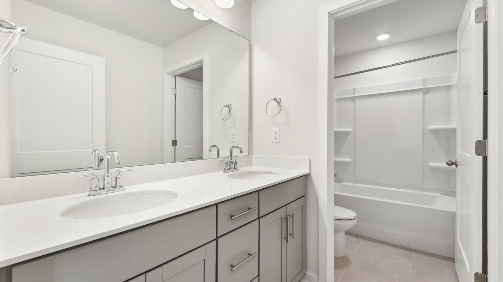 bathroom with double sinks, and separate toilet and bathtub and shower combination