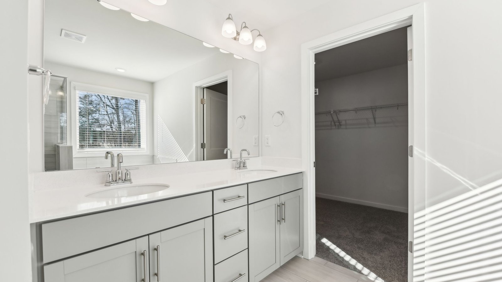 primary bathroom with double sinks, glass door shower, and bathtub