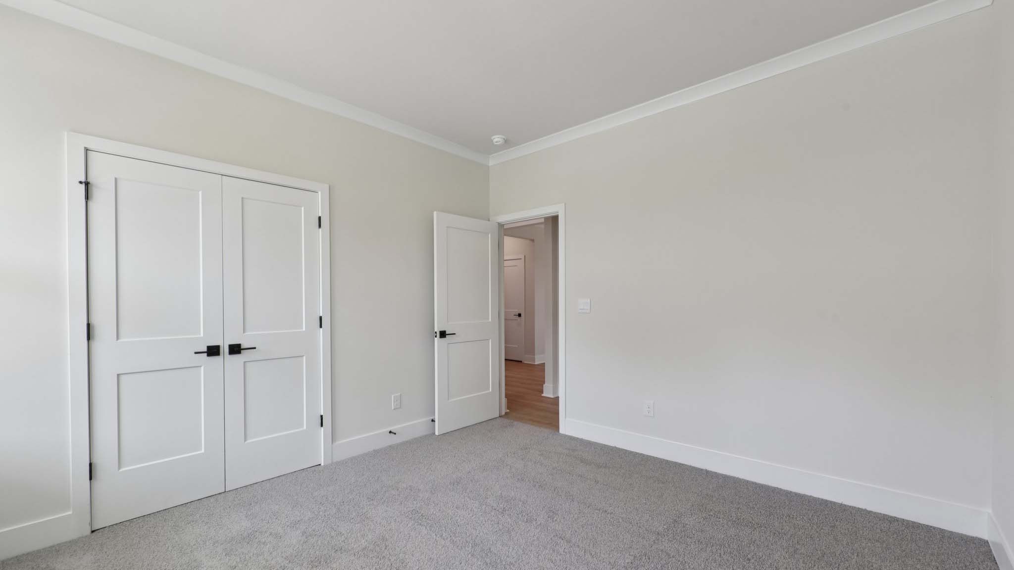 Carpeted bedroom with large windows