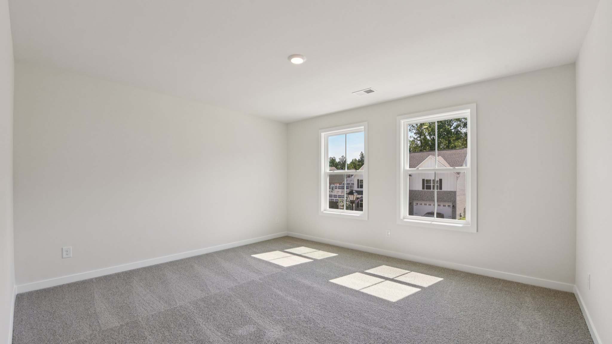 Carpeted bedroom with windows