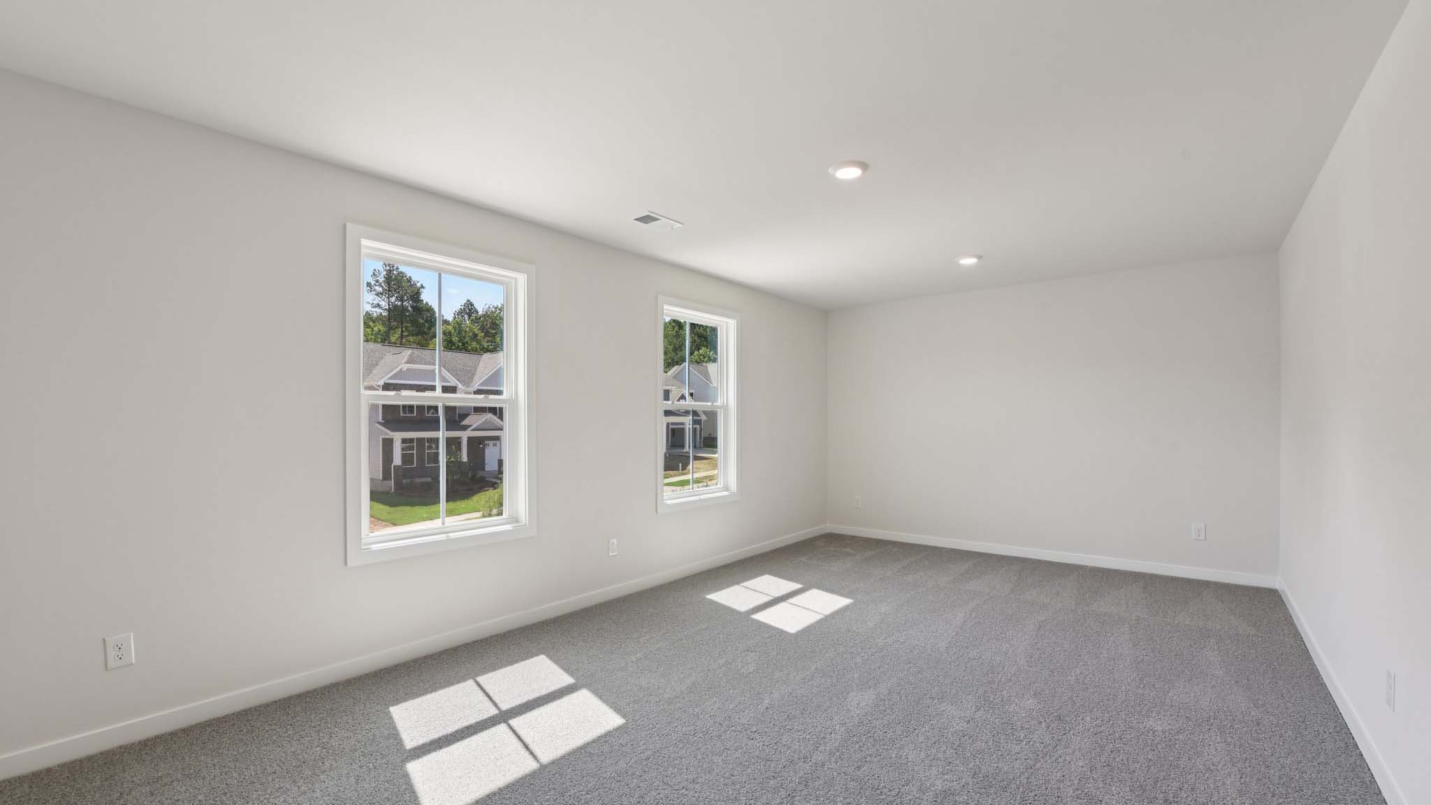 Carpeted bedroom with windows