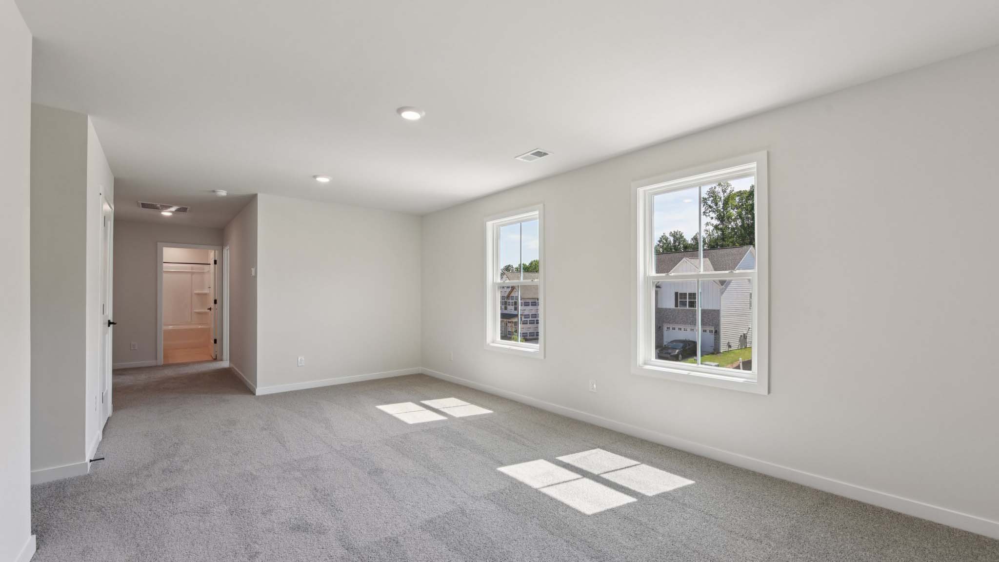 Carpeted bedroom with windows