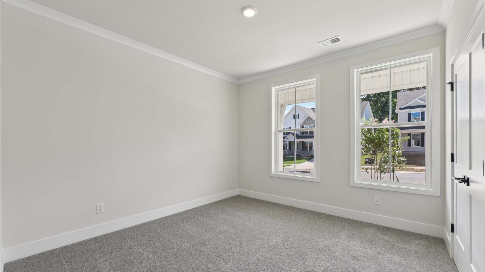 Carpeted bedroom with large windows