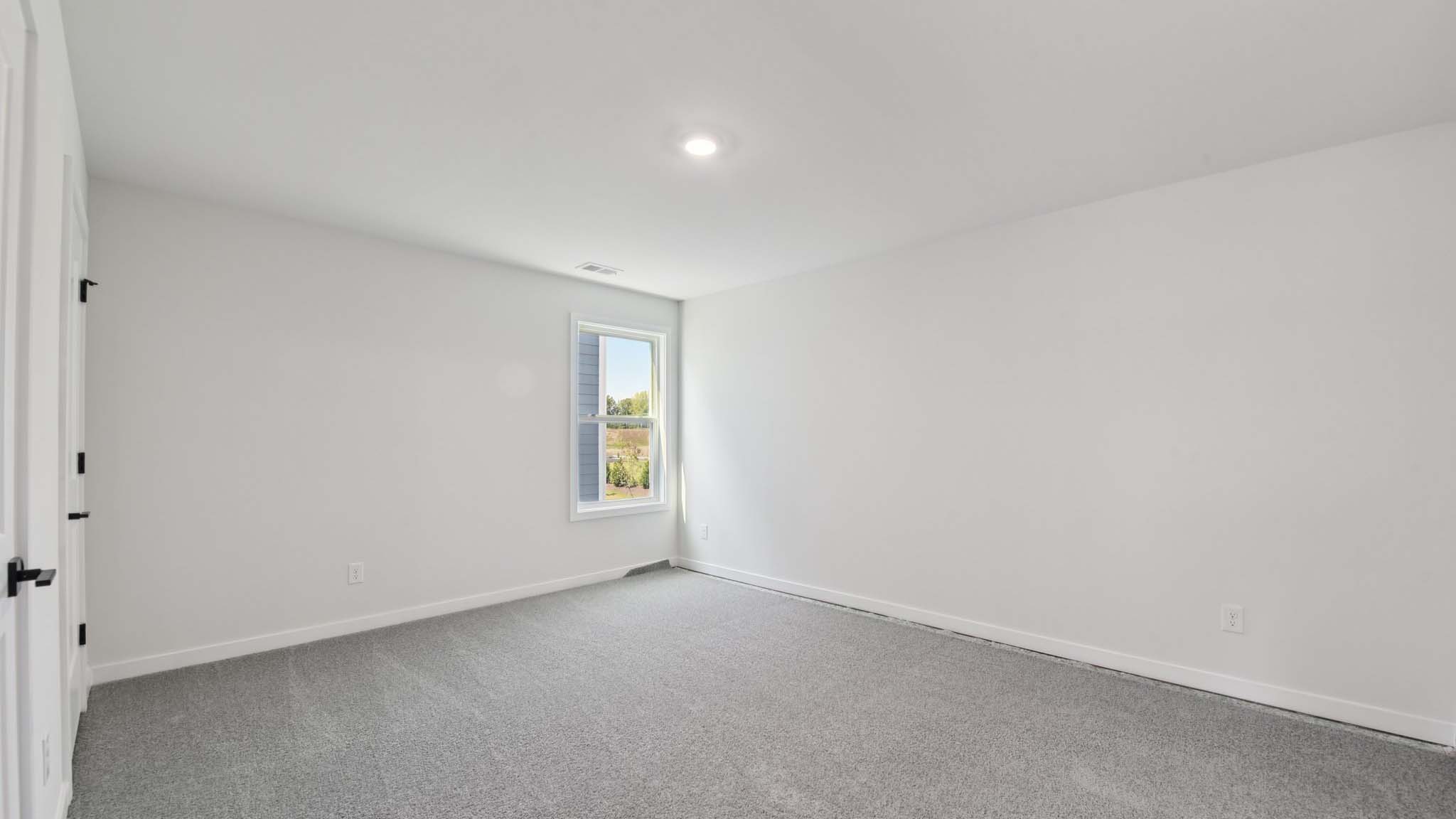 Carpeted bedroom with windows