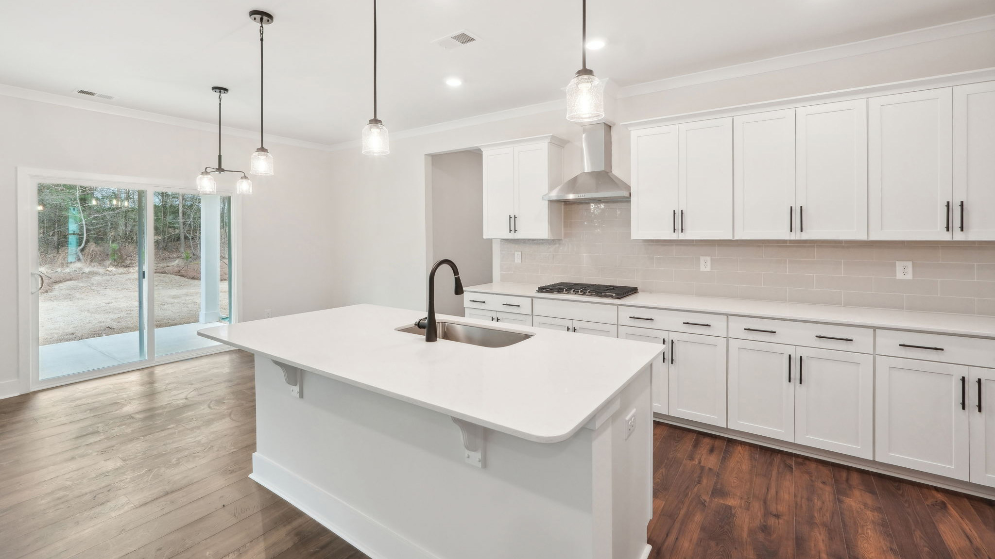 open concept kitchen with large island, white cabinets and countertops and stainless steel appliances