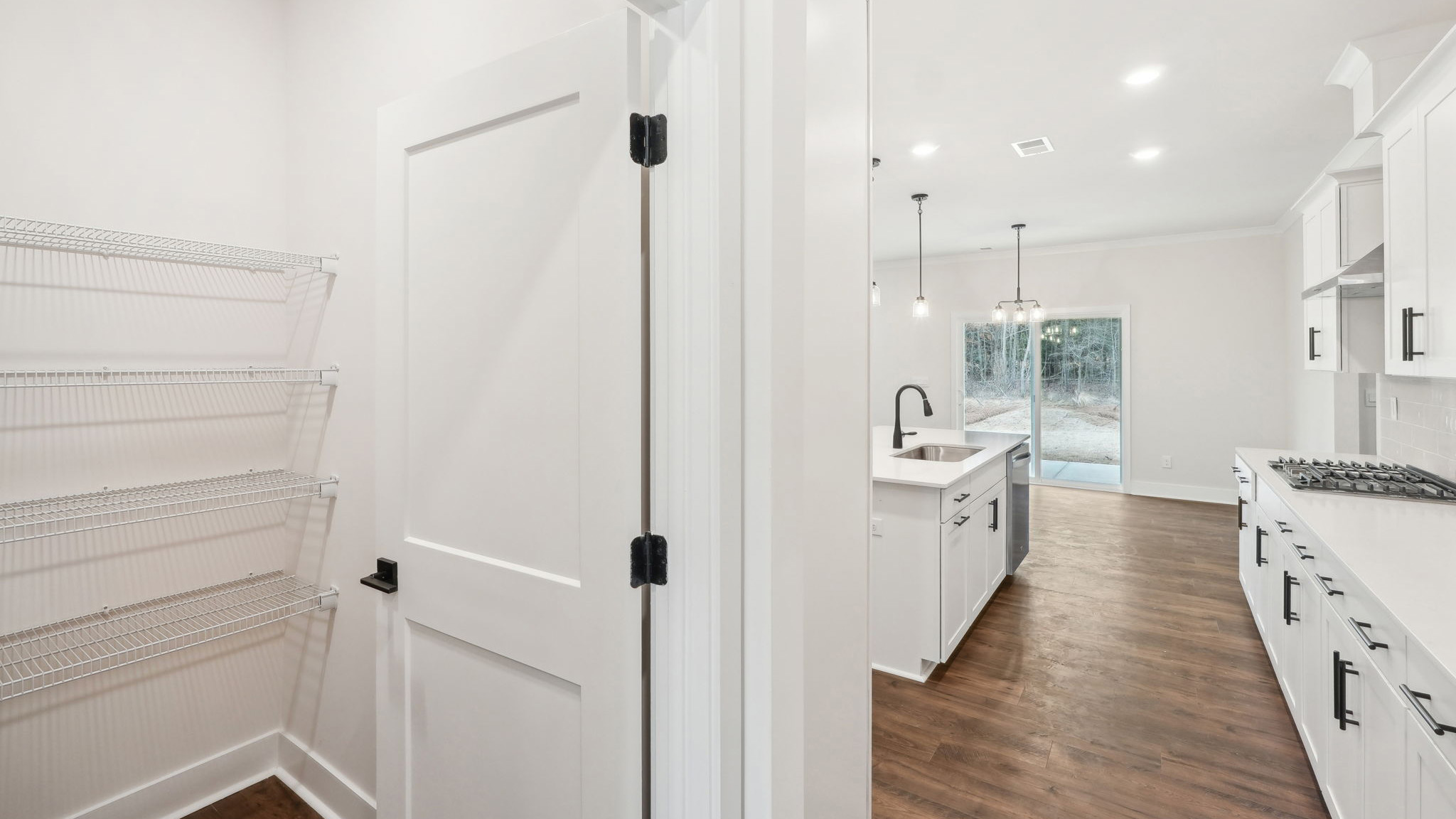 open concept kitchen with large island, white cabinets and countertops and stainless steel appliances
