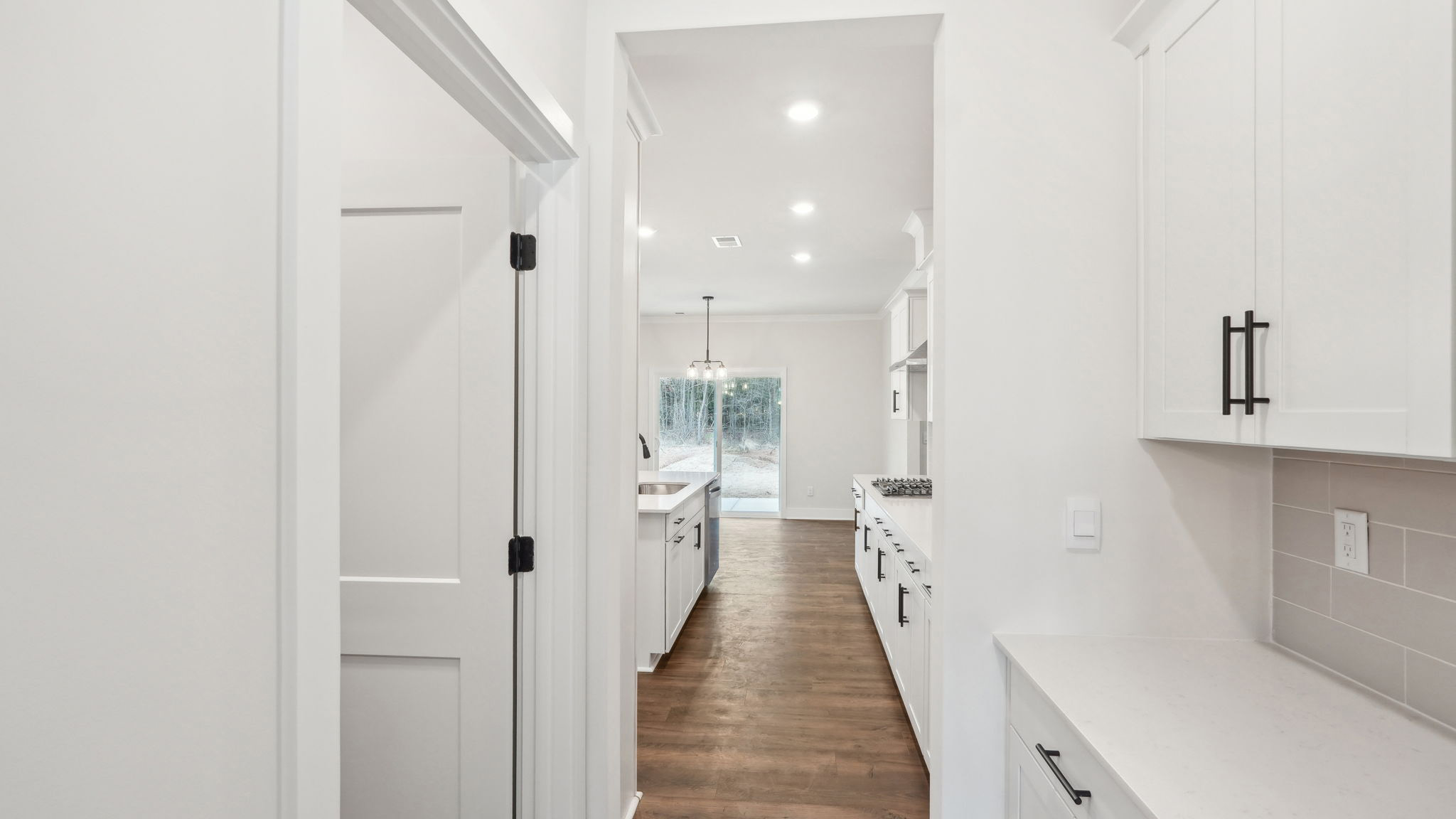 open concept kitchen with large island, white cabinets and countertops and stainless steel appliances