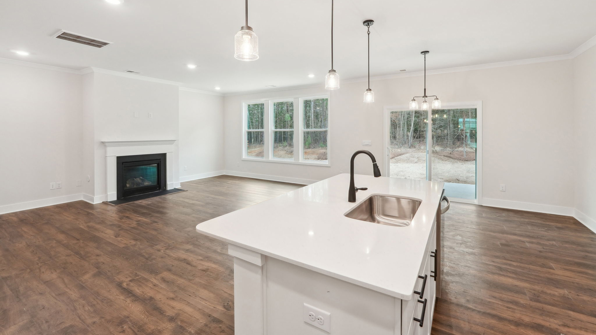 open concept kitchen with large island, white cabinets and countertops and stainless steel appliances