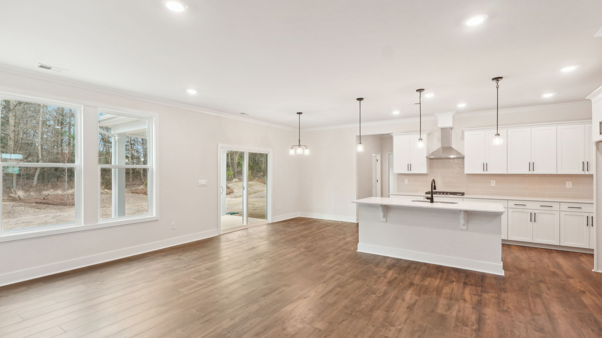 open concept kitchen with large island, white cabinets and countertops and stainless steel appliances