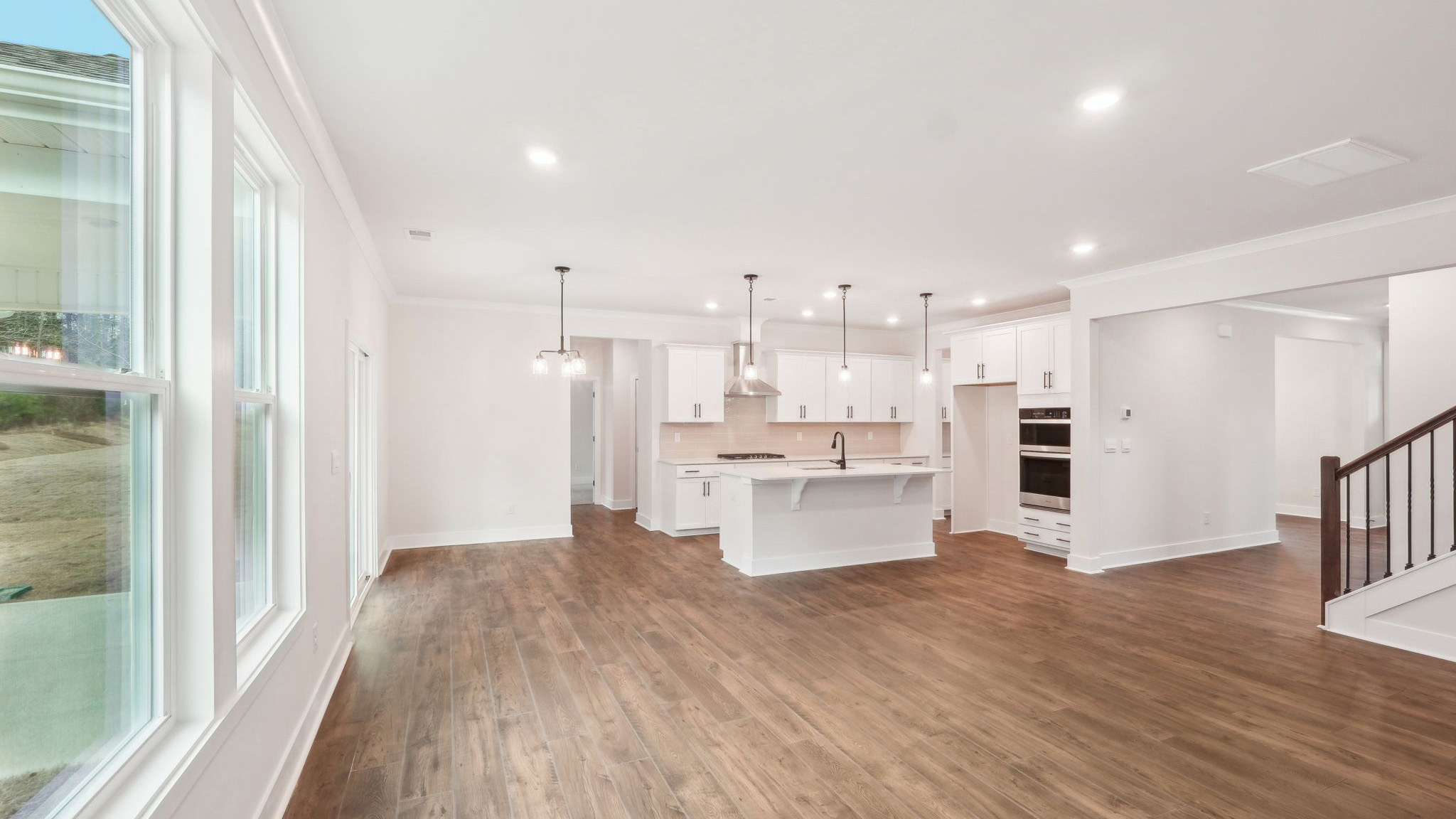 open concept living area with 3 large windows and fireplace