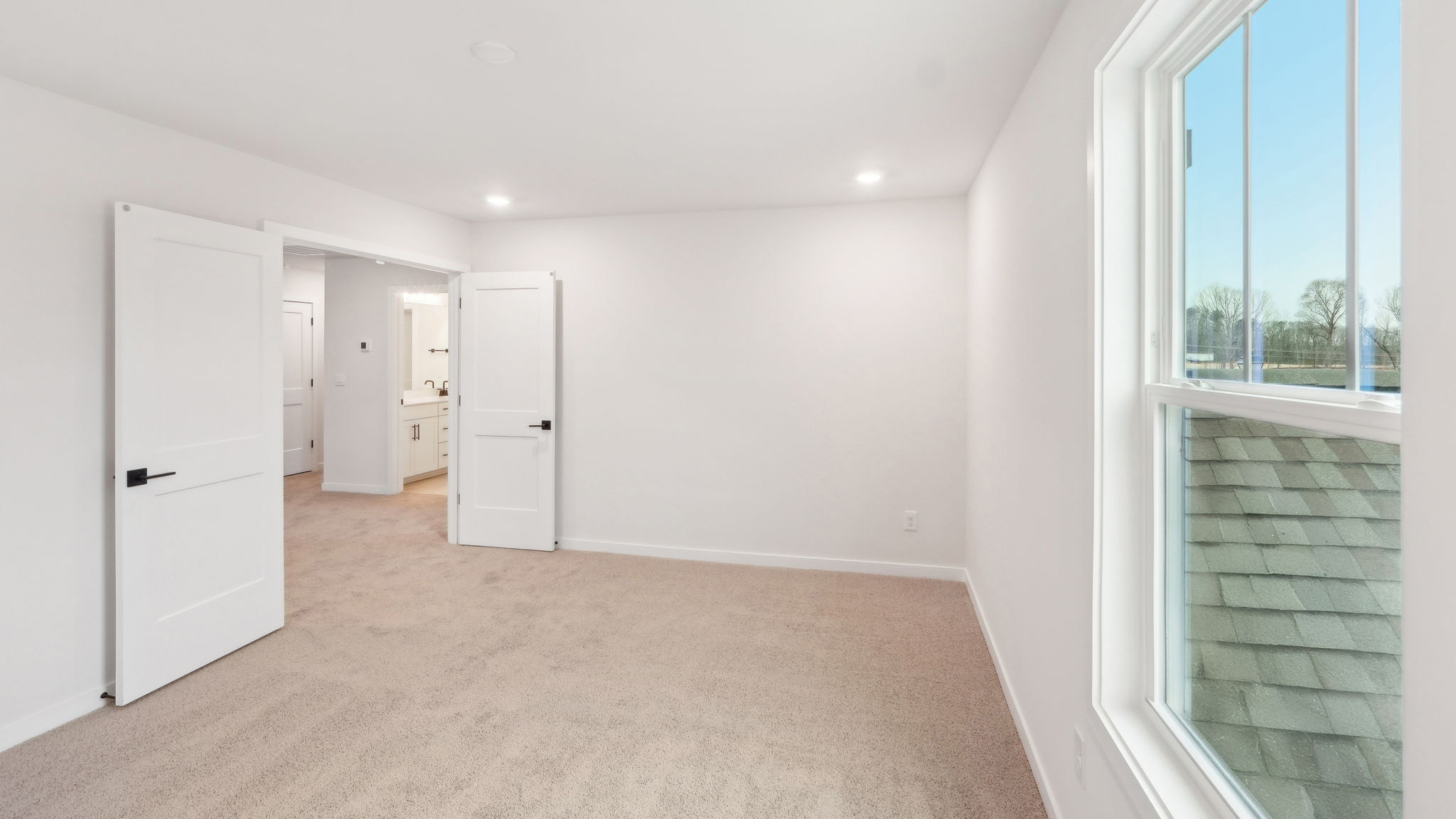 carpeted bedroom with large window