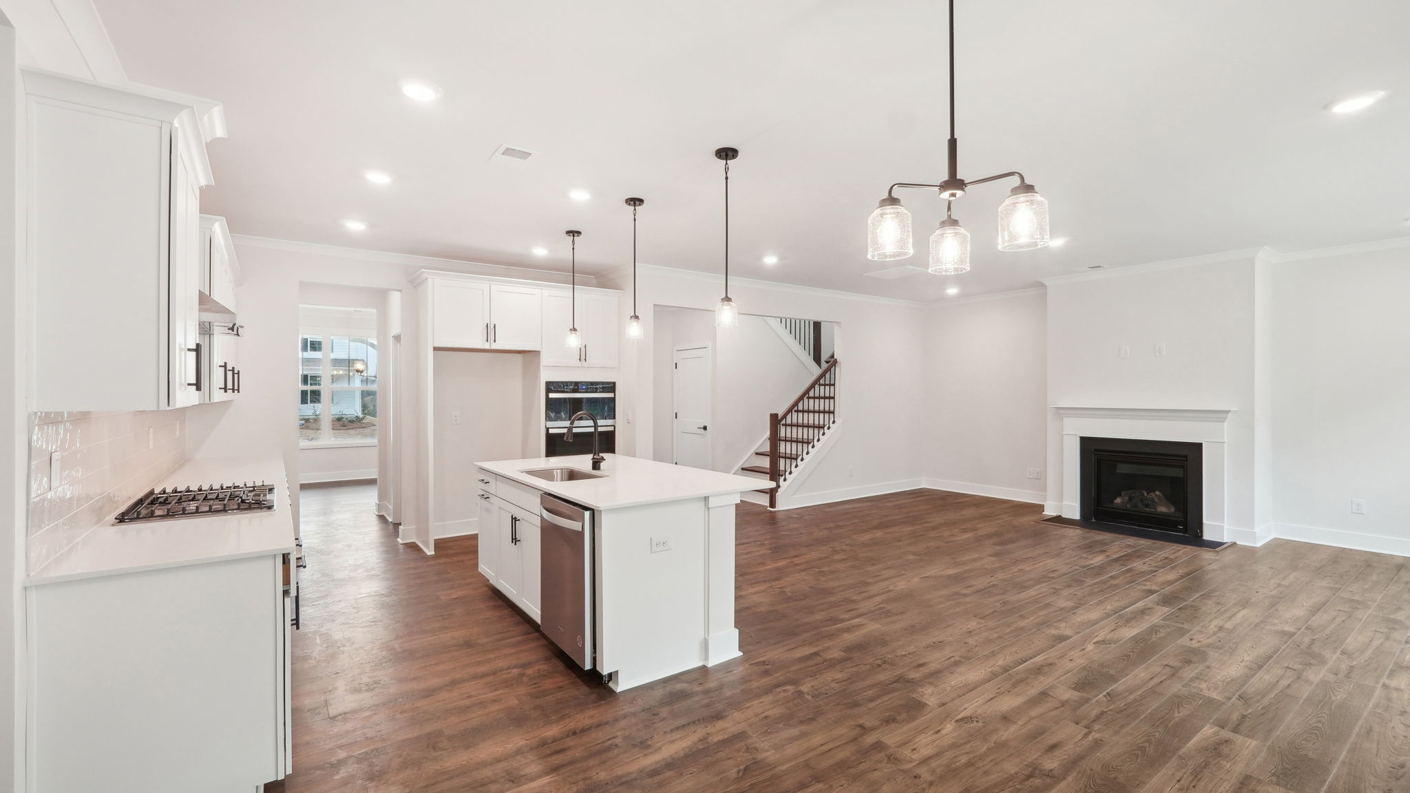 open concept kitchen with large island, white cabinets and countertops and stainless steel appliances