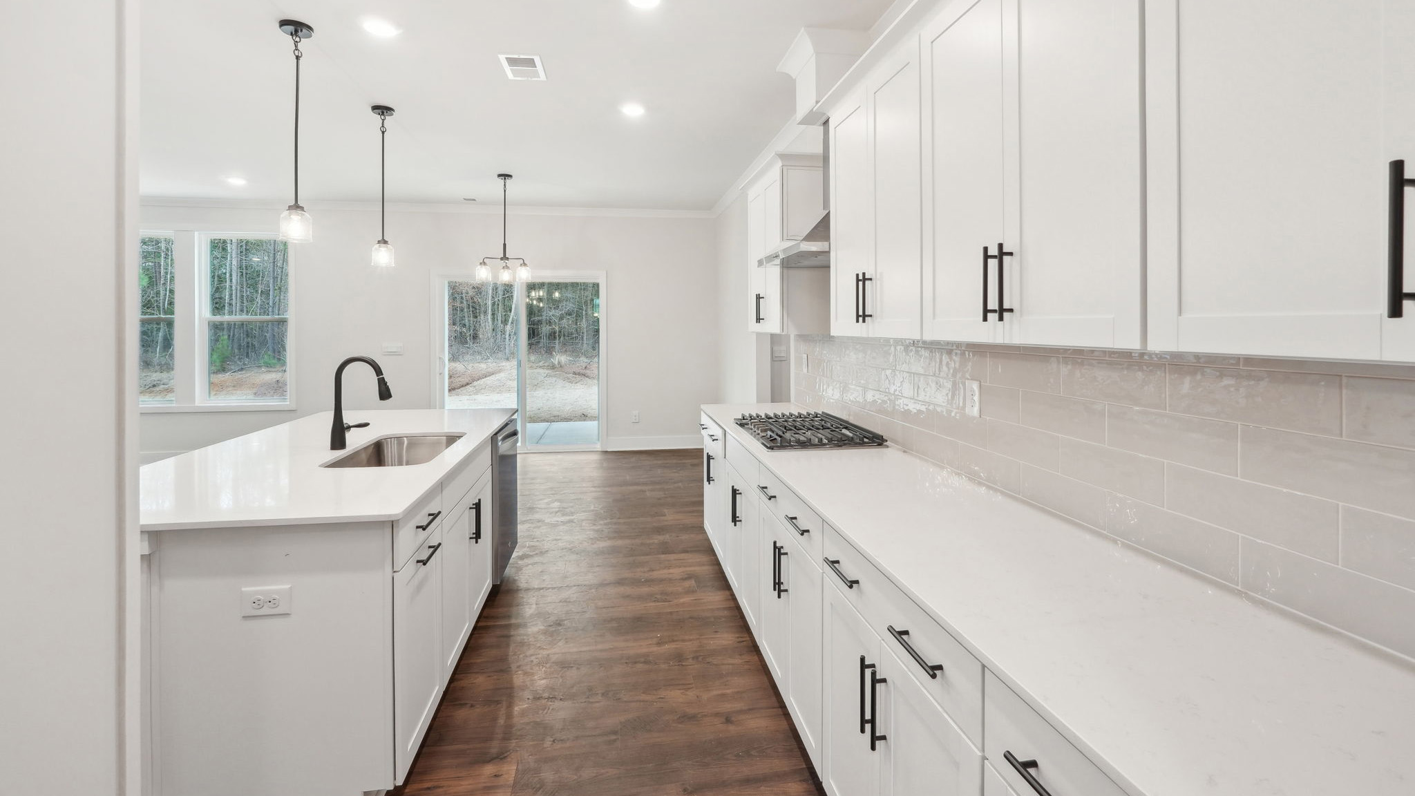 open concept kitchen with large island, white cabinets and countertops and stainless steel appliances