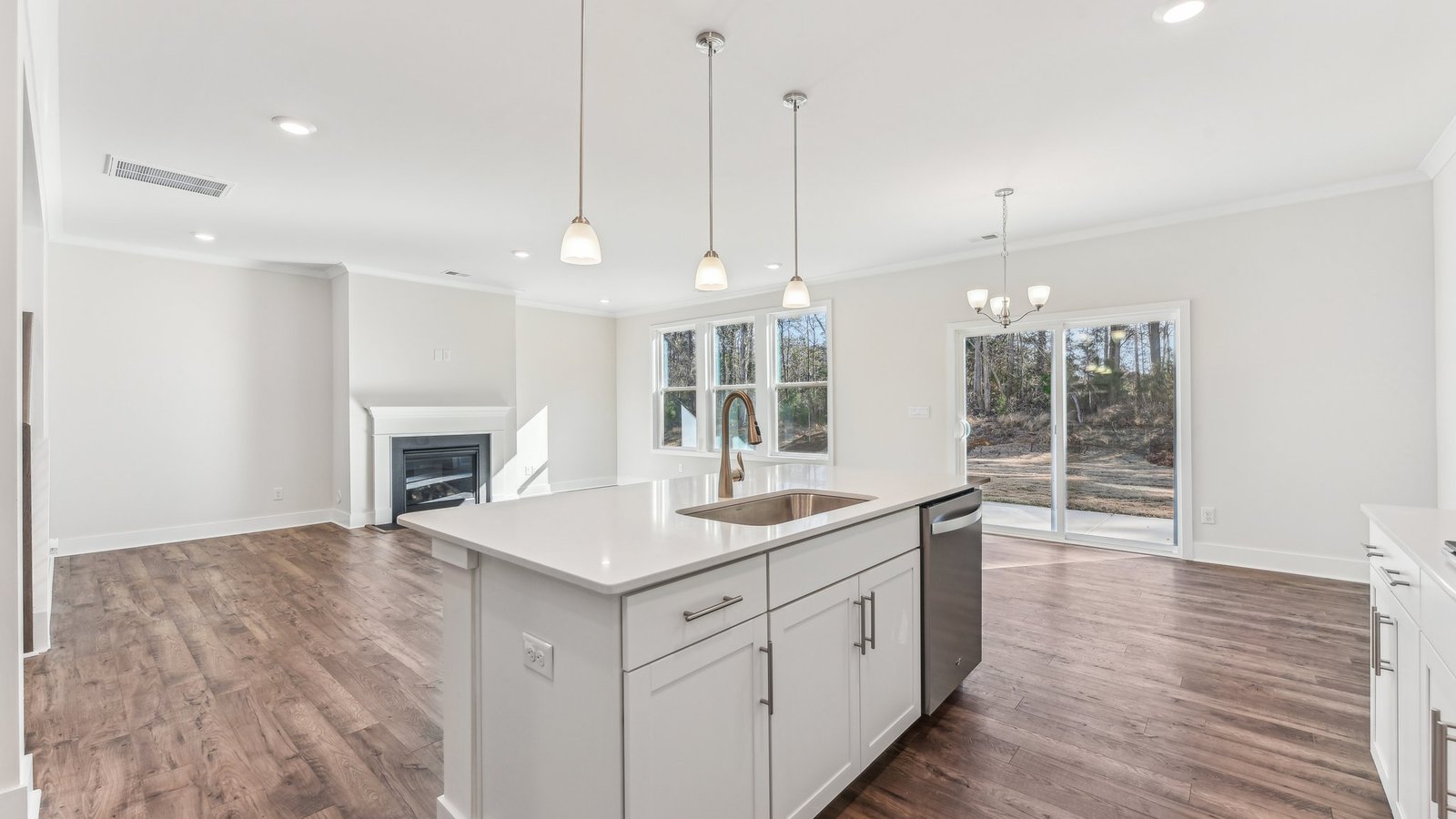 open concept kitchen with large island, white cabinets and countertops and stainless steel appliances