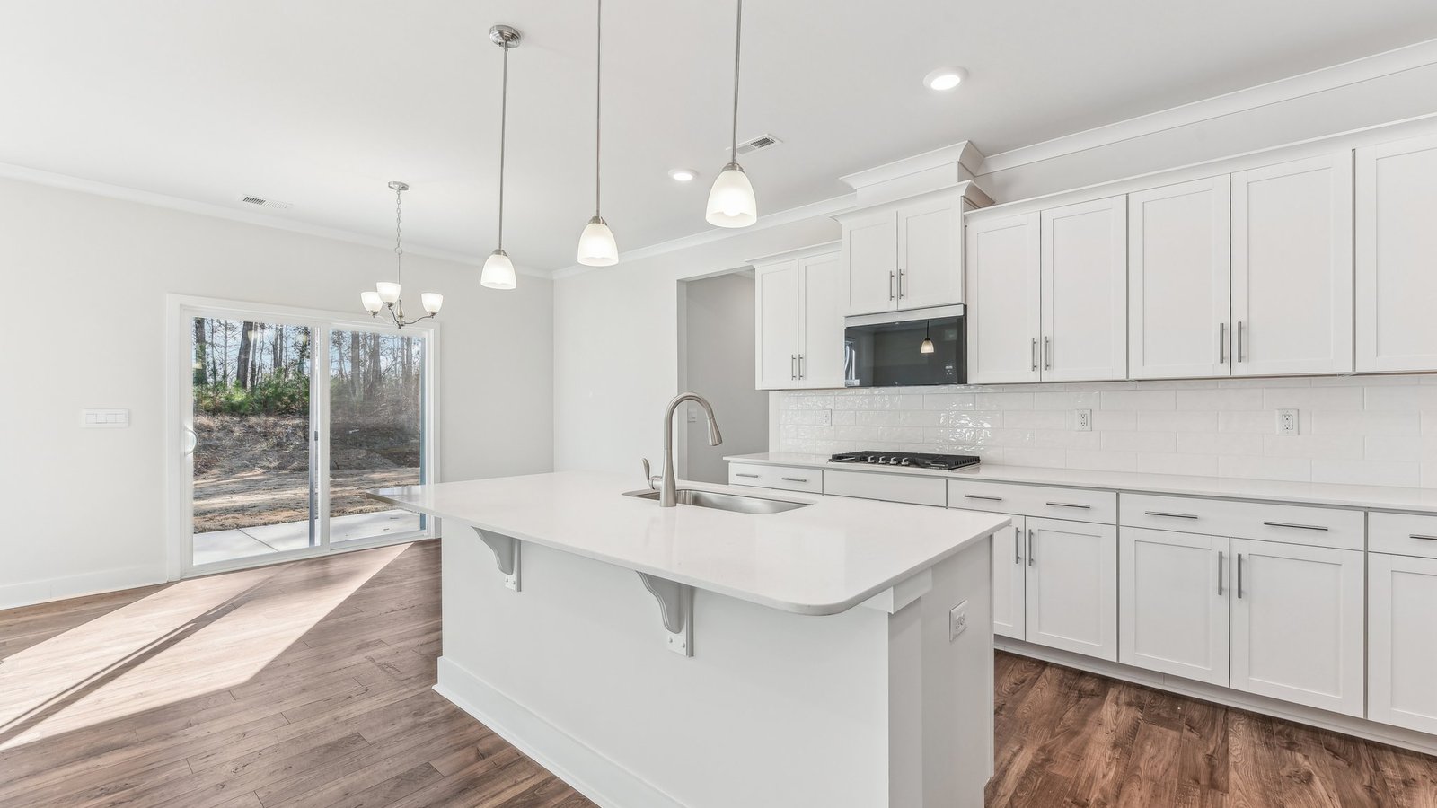open concept kitchen with large island, white cabinets and countertops and stainless steel appliances