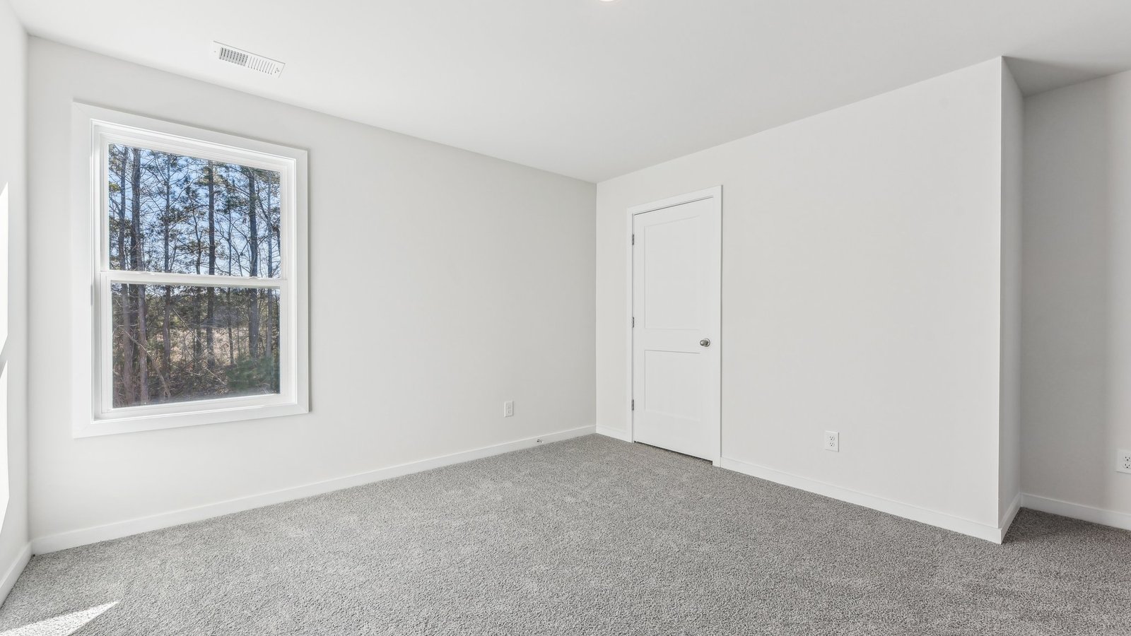 carpeted bedroom with large window