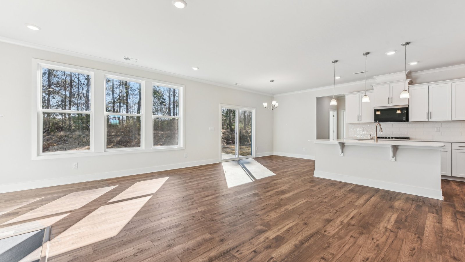 open concept living area with 3 large windows and fireplace