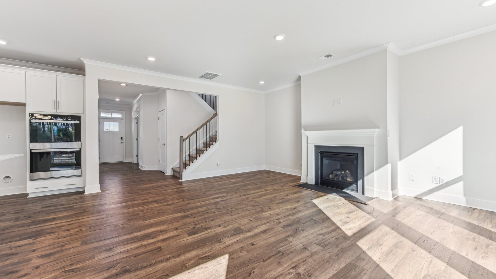 open concept living area with 3 large windows and fireplace
