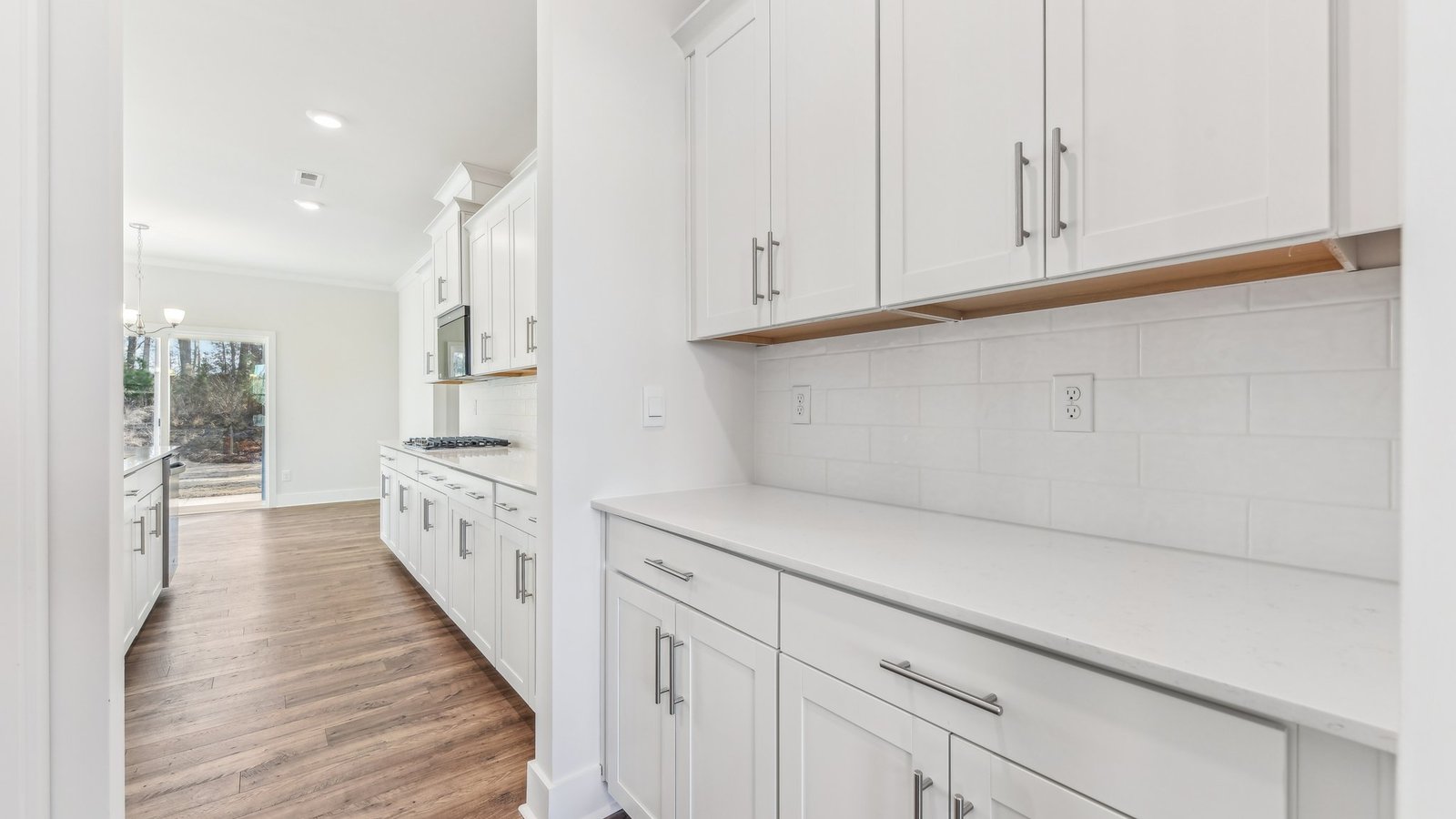open concept kitchen with large island, white cabinets and countertops and stainless steel appliances