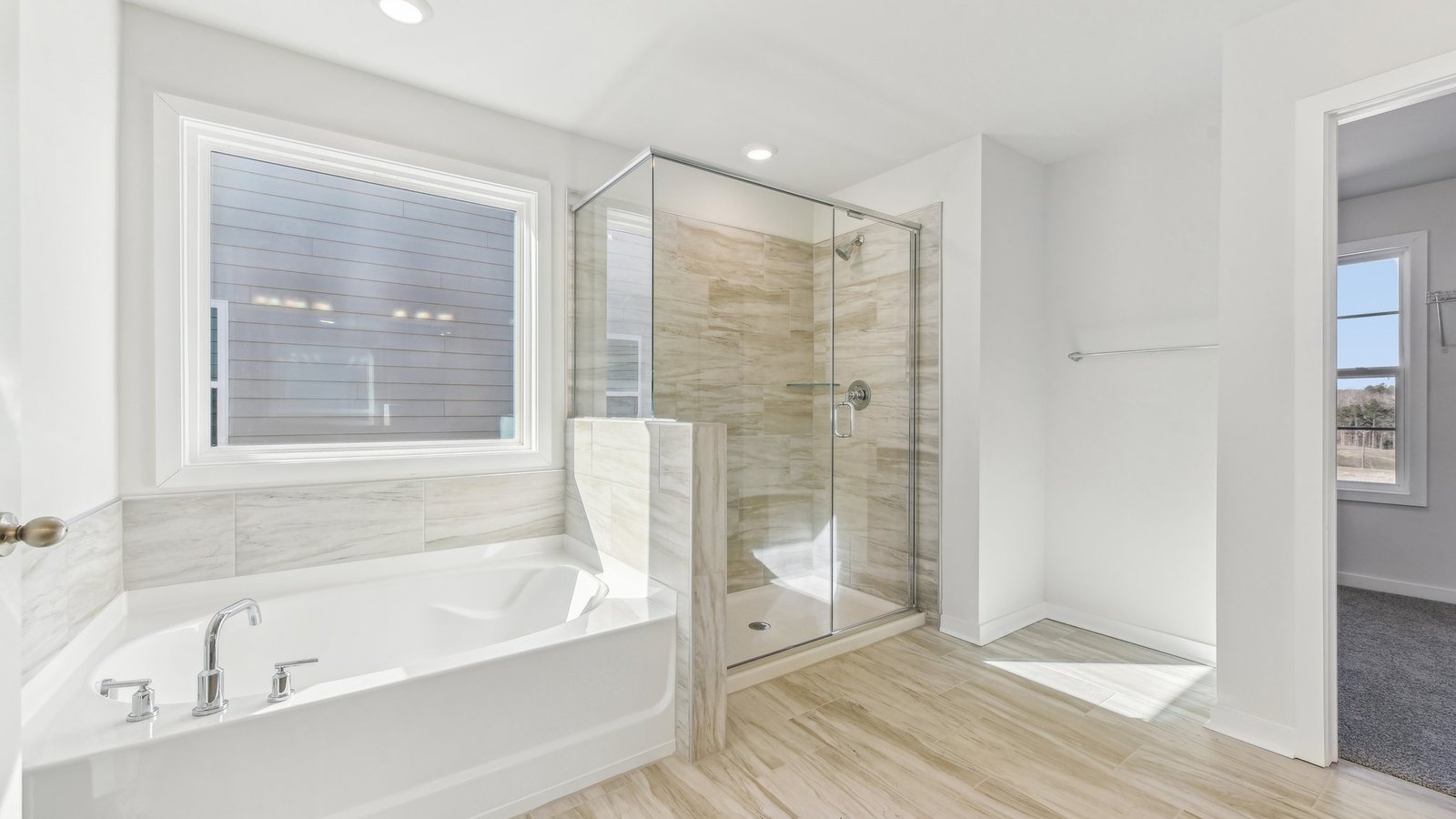 primary bathroom with dual vanity, bathtub and glass door shower