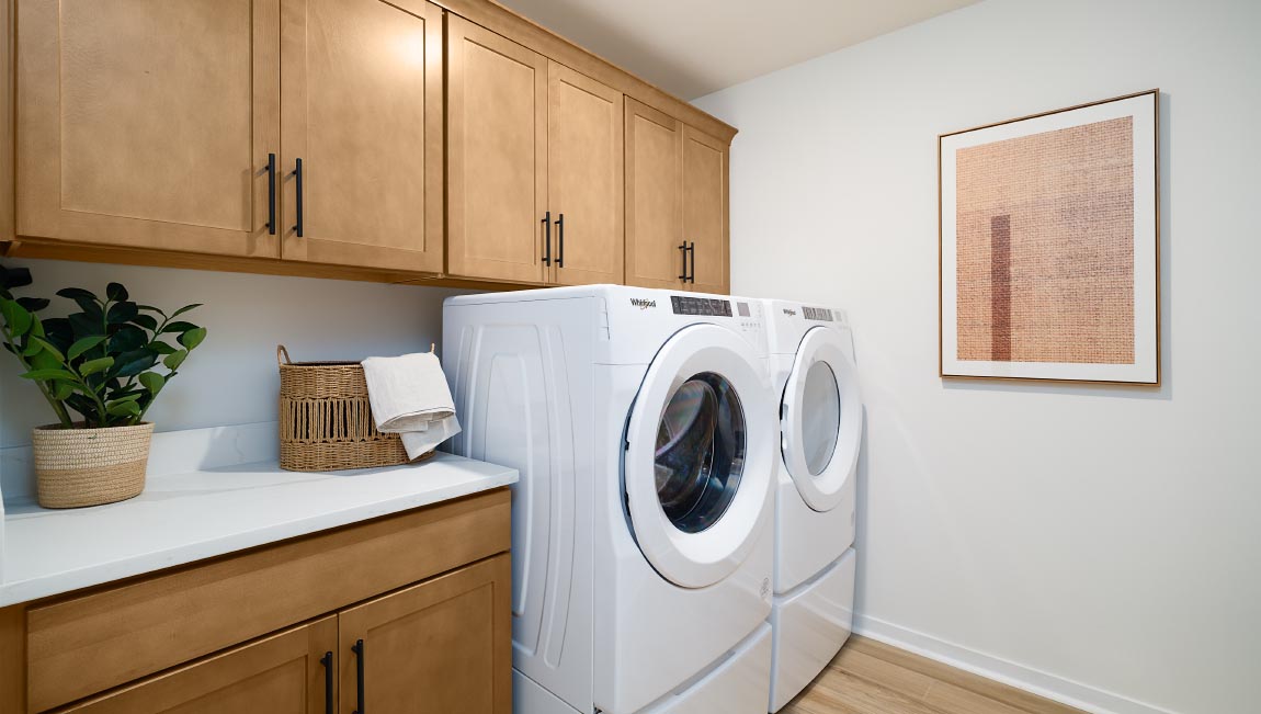 Laundry room with brown built in cabinets for storage