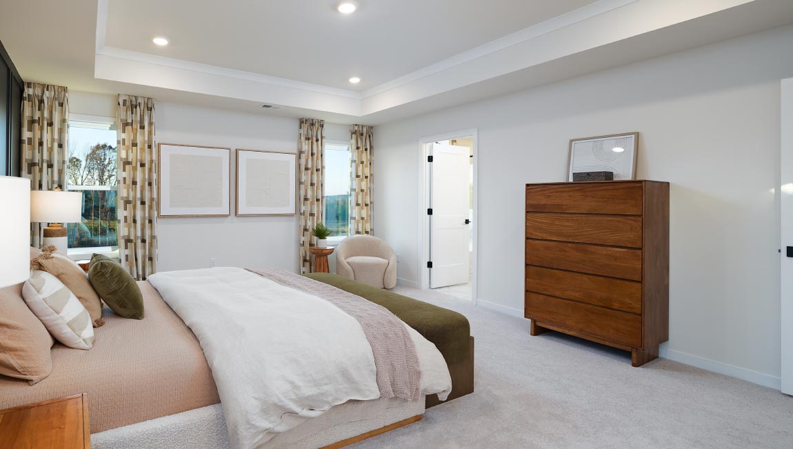 Primary carpeted bedroom with large windows