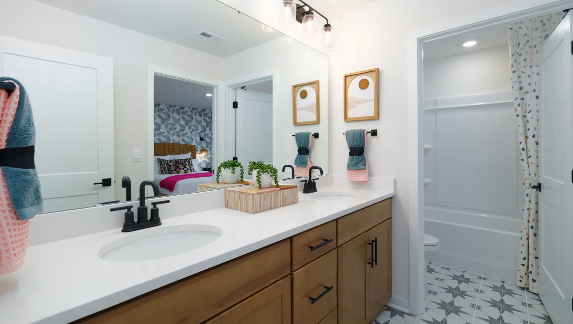 Primary bathroom with brown cabinets and large glass shower