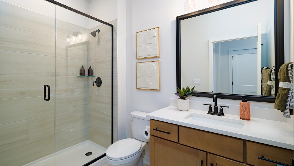 Bathroom with brown cabinets and glass shower