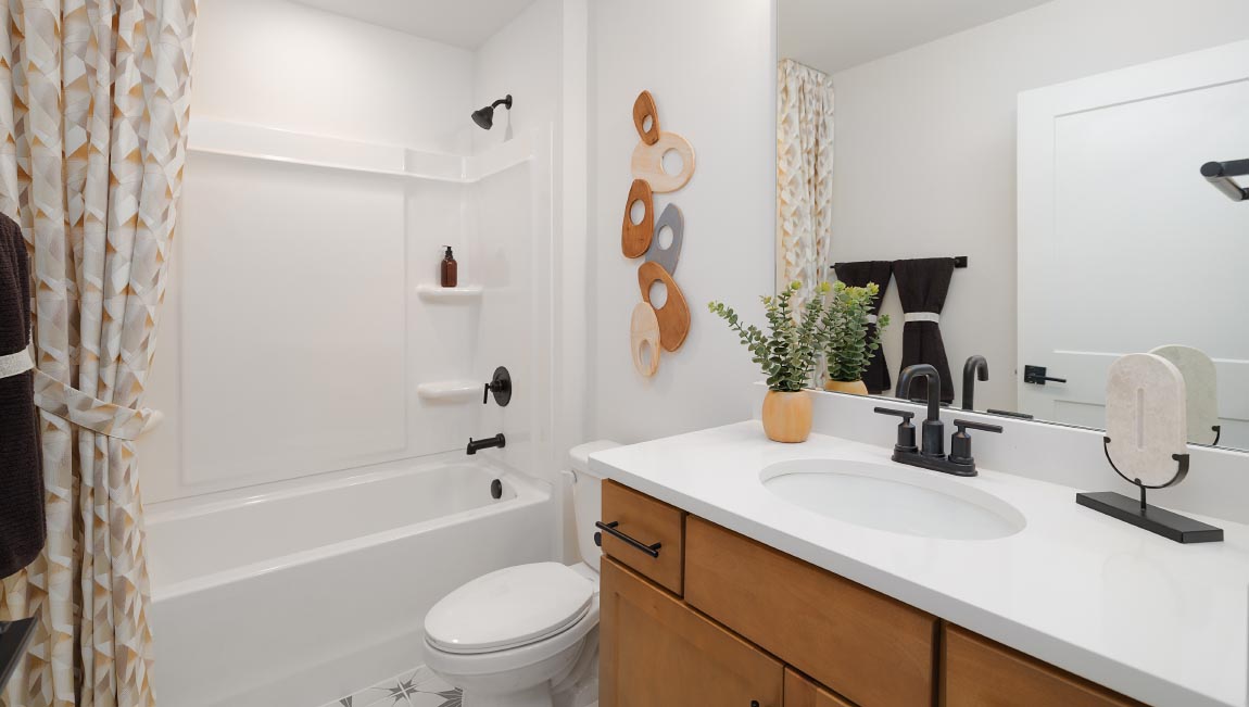 Bathroom with brown cabinets and tub shower